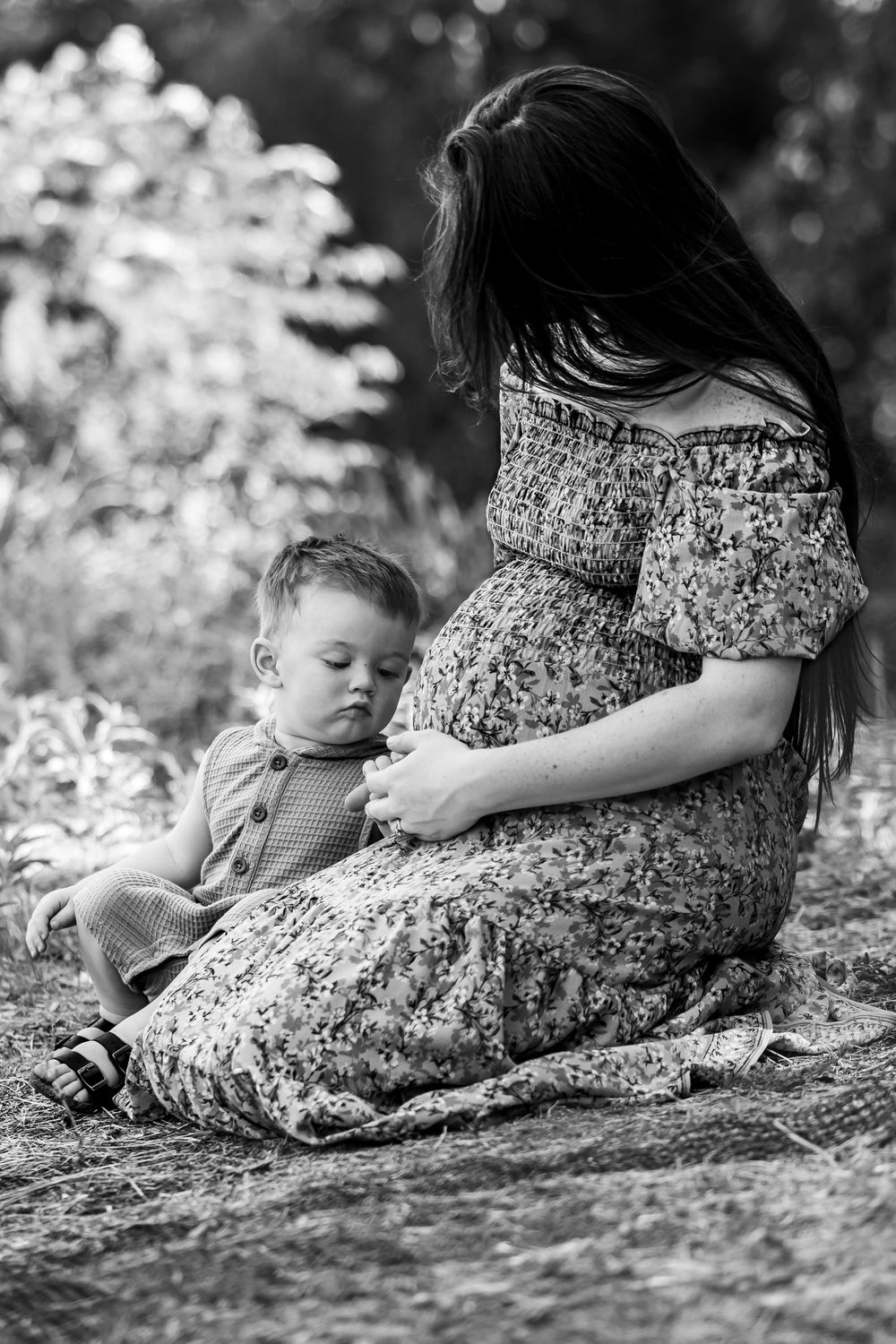 Black and white photo sequence showing a quiet moment between child and parent sitting together in nature at fort worth photo session