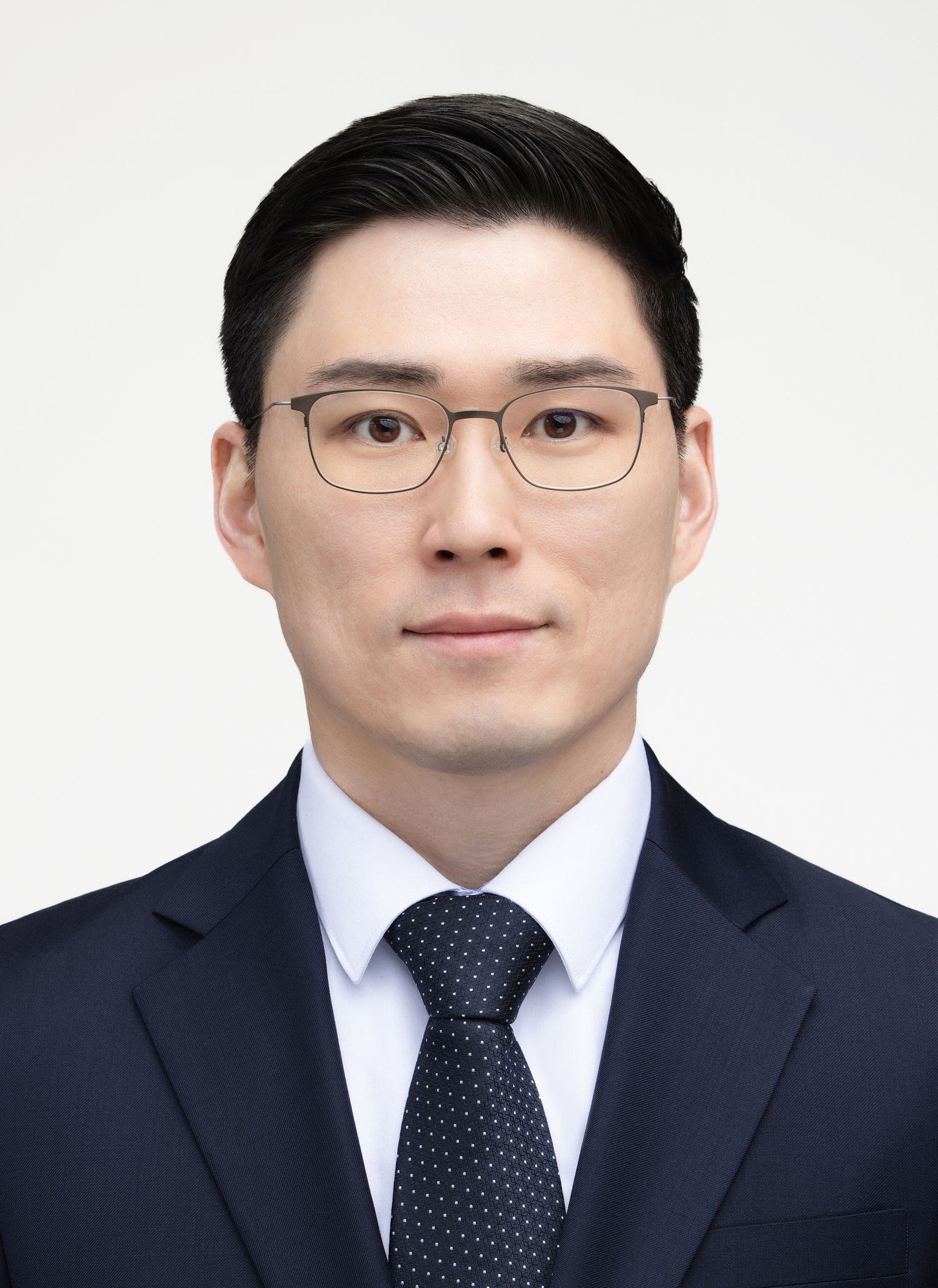 Professional business headshots showing the same person in a navy suit and tie with glasses against a white background.