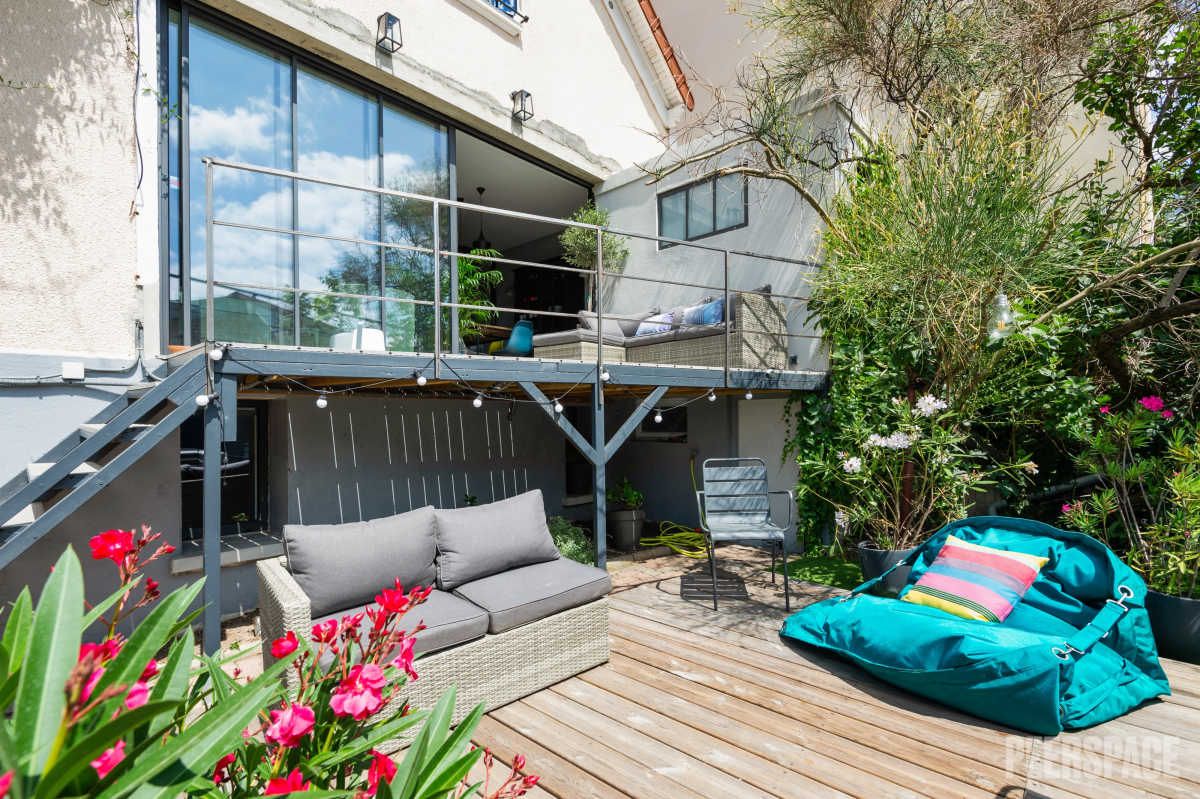 Femme entrepreneure posant près d’une grande fenêtre dans un décor chic parisien