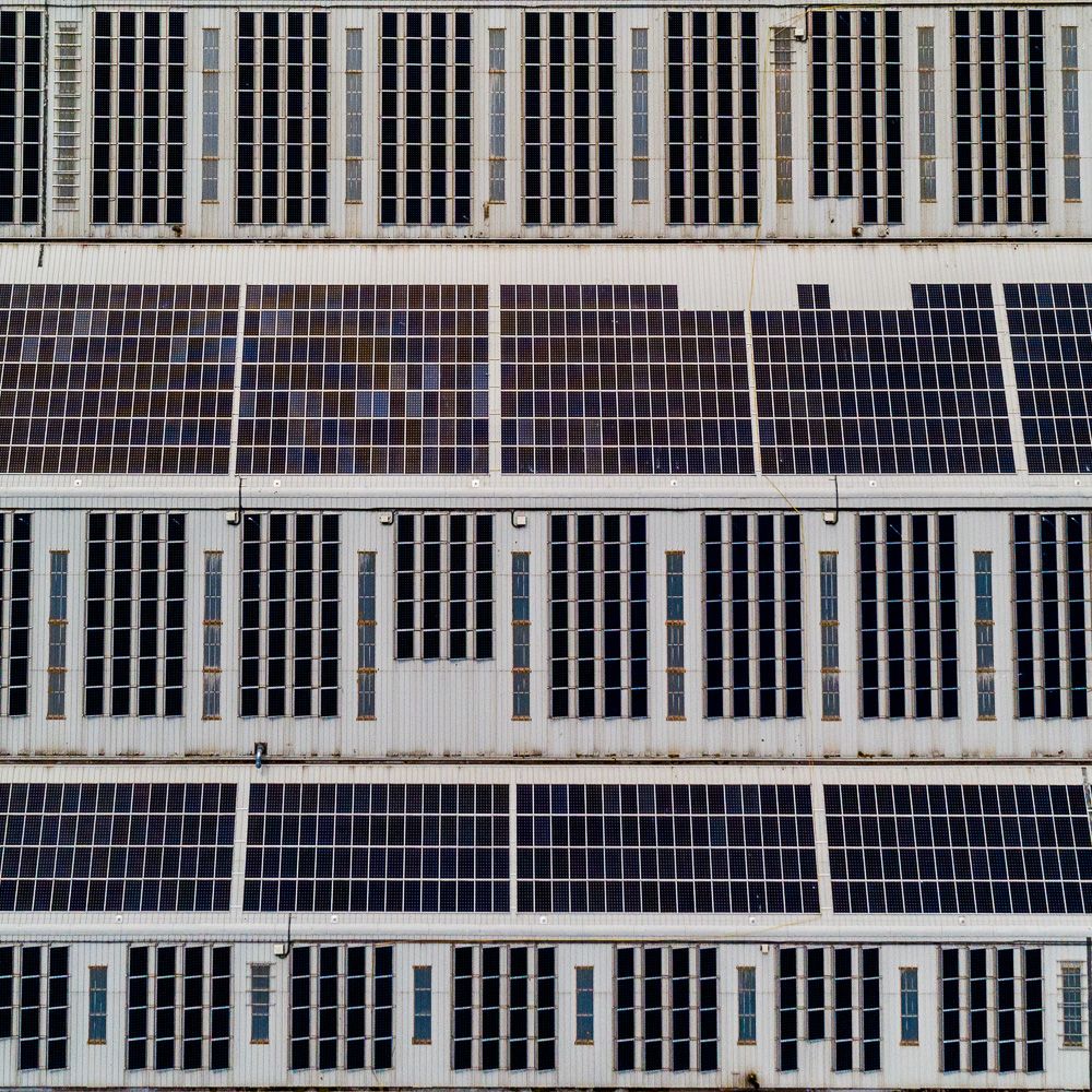Architectural drone photograph of solar panels on industrial unit.