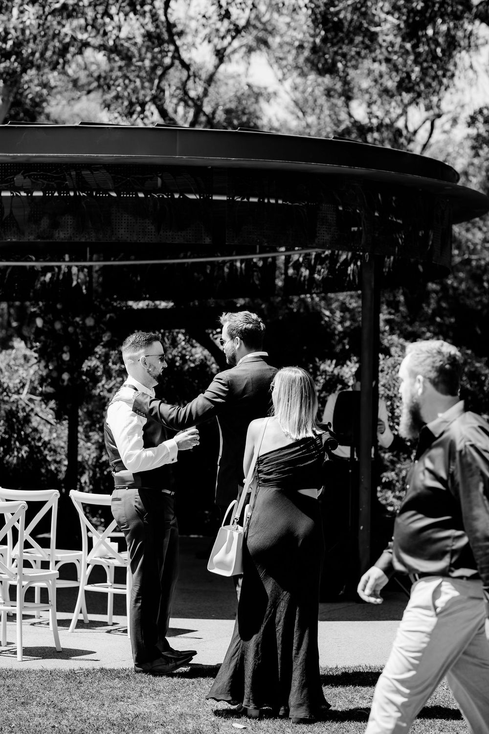 Vintage black and white photograph shows couples dancing outdoors under a canopy in a romantic slow dance setting.