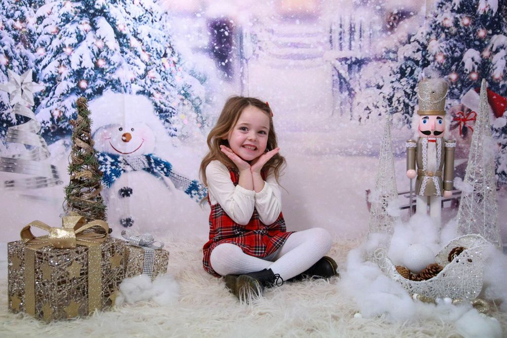 Festive winter scene with snow covered trees, wrapped presents and holiday decorations in a cozy studio setting.