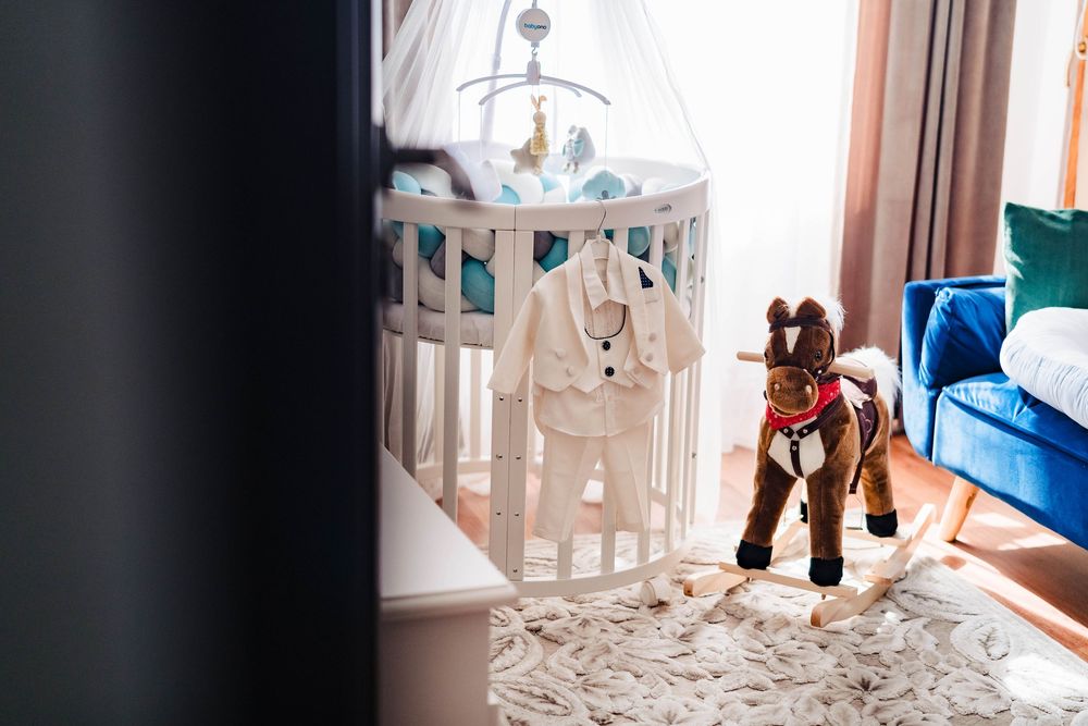 Interior view of a nursery with white furniture and natural lighting.
