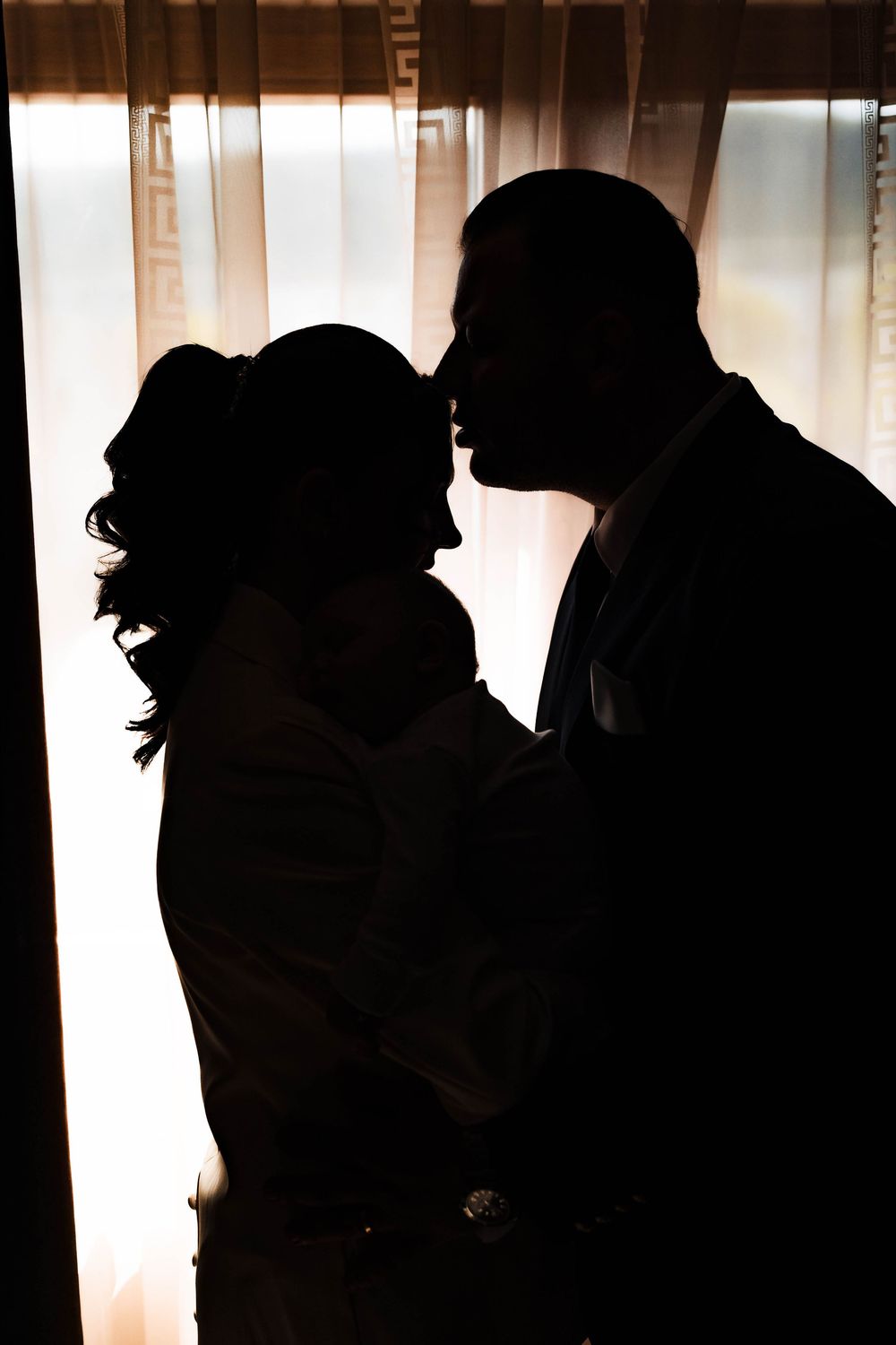 Silhouettes of people in a backlit window creating dramatic shadows.