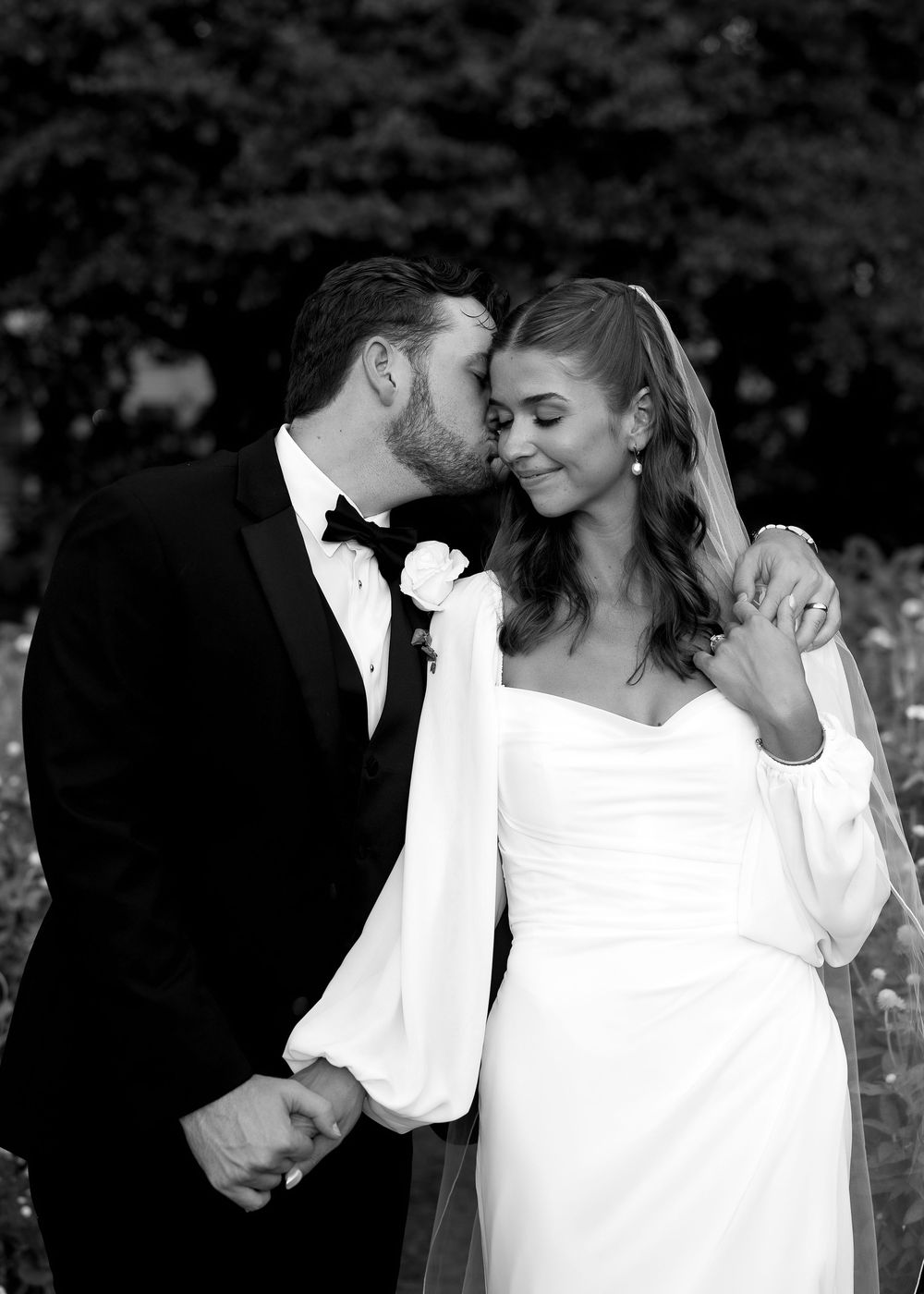 Intimate black and white wedding portrait showing tender romantic moment.