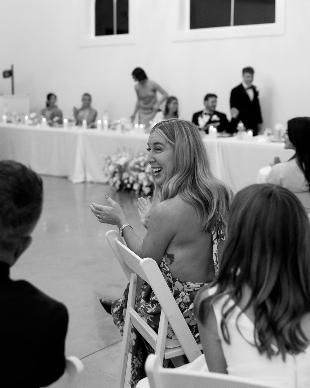 Wedding guests seated at tables during an indoor reception celebration.