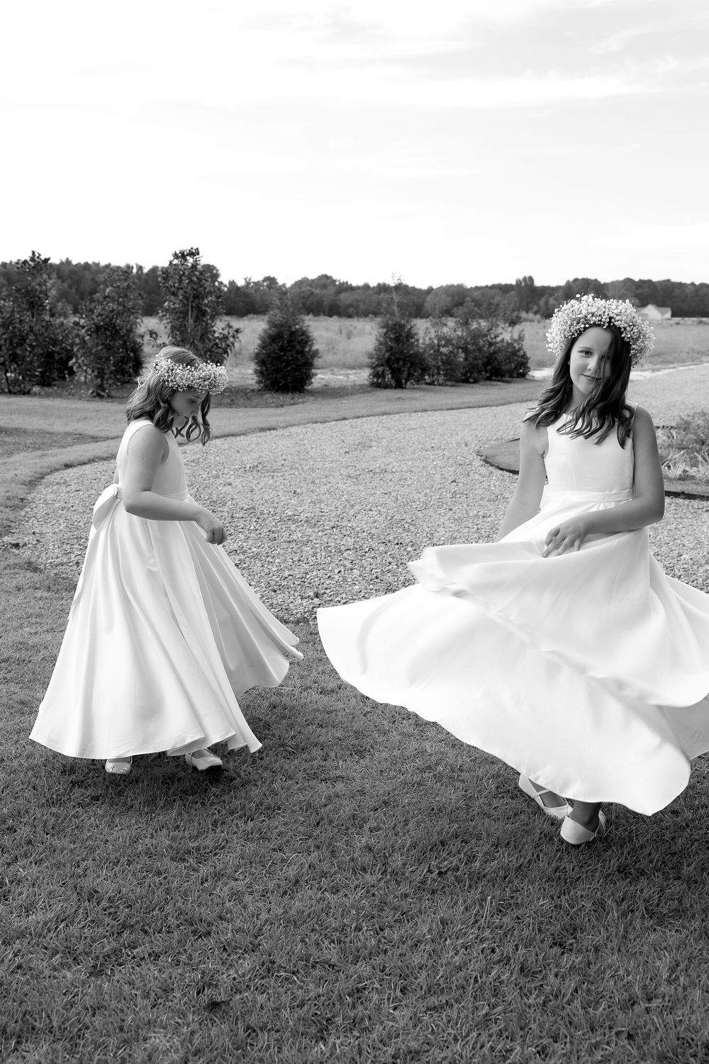Black and white photo series of flowing white dresses twirling in a grassy field.
