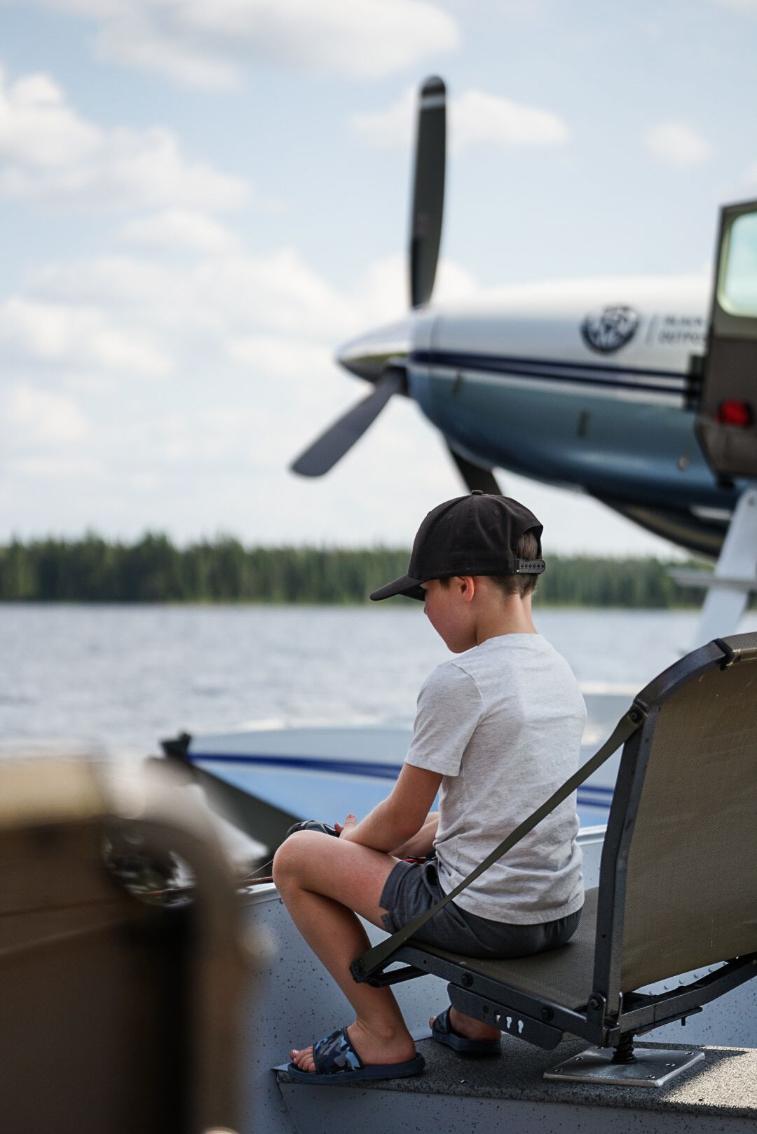 Small aircraft parked on a dock with fishing equipment visible in the foreground.