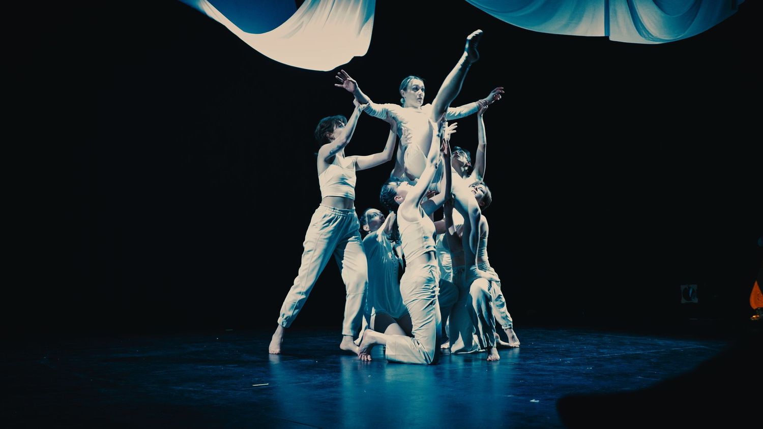 Photograph of dancers lifting up another dancer