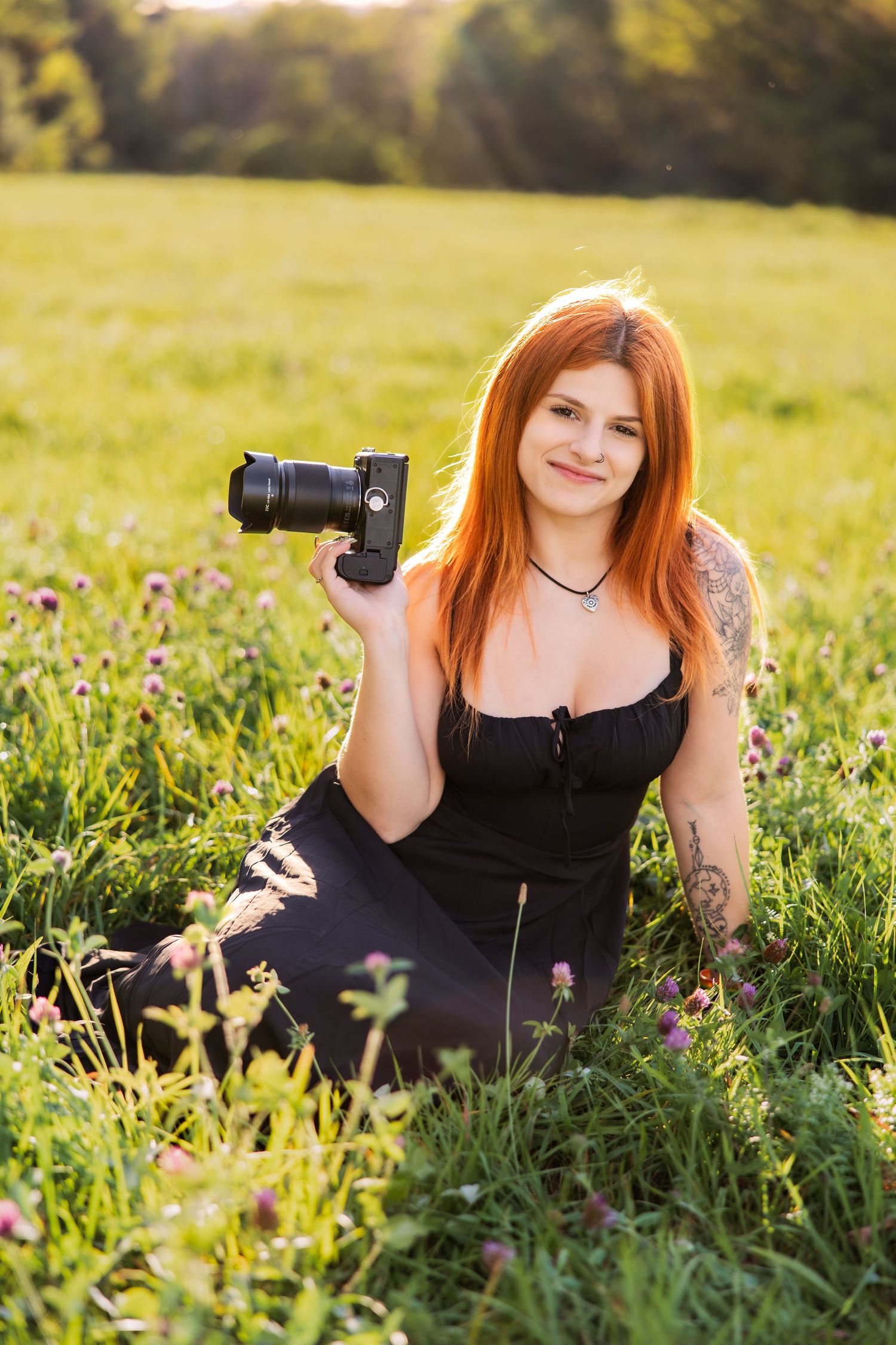 Photographer in black dress lying in wildflower field during golden hour.