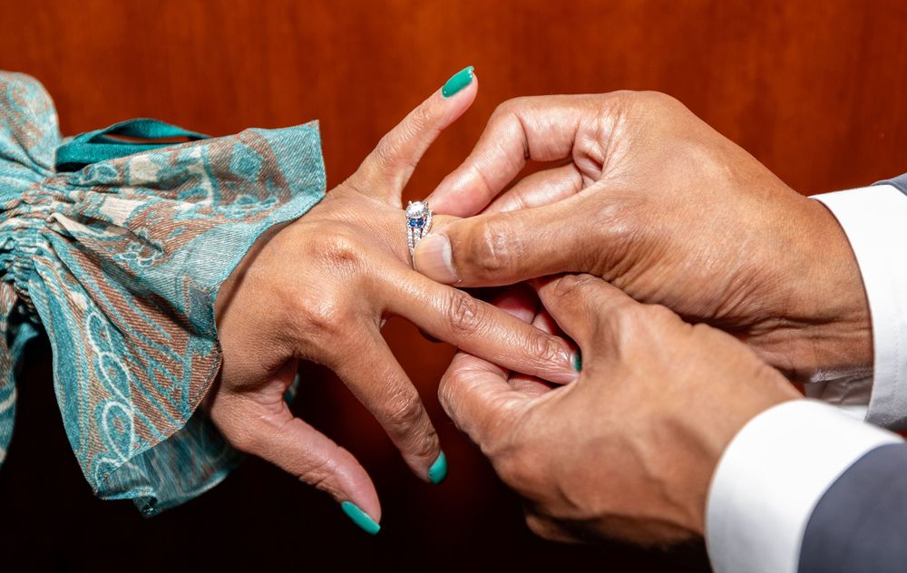 Close-up shot of hands exchanging rings during a ceremony.