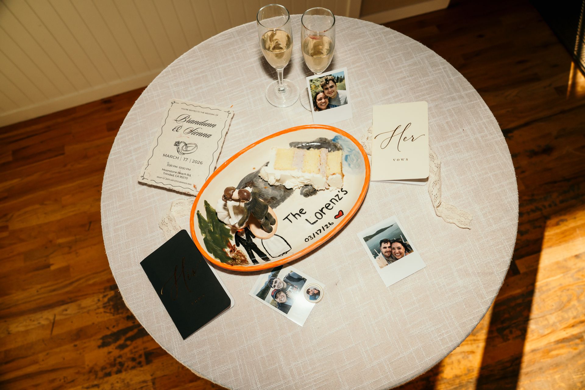 Wedding reception table displaying The Lorenz personalized platter, photos, champagne flutes, and keepsakes.