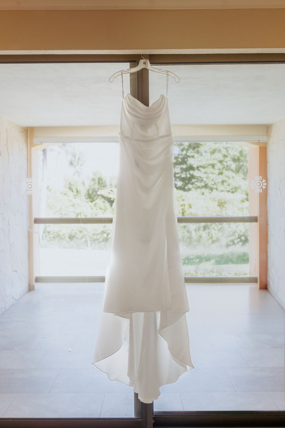 wedding dress hanging in balcony window at Barcelo Maya Palace, Mexico resort wedding photography packages from Canada, destination photos