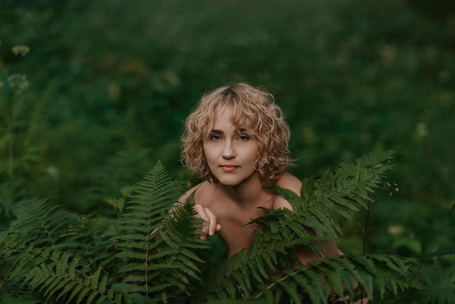 Artistic composition of fern leaves and natural elements in forest setting.