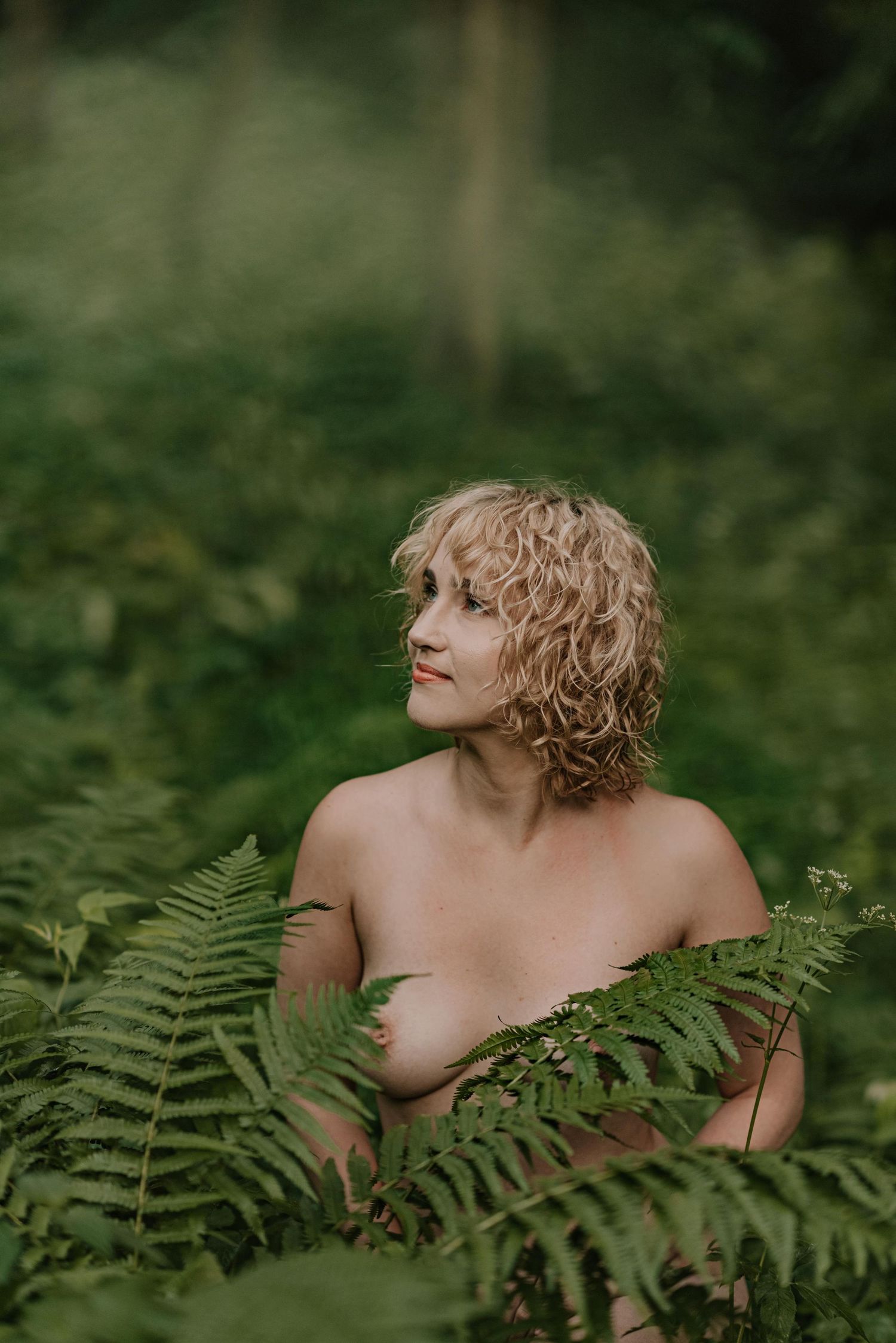 Dramatic forest portrait with fern leaves creating natural framing.
