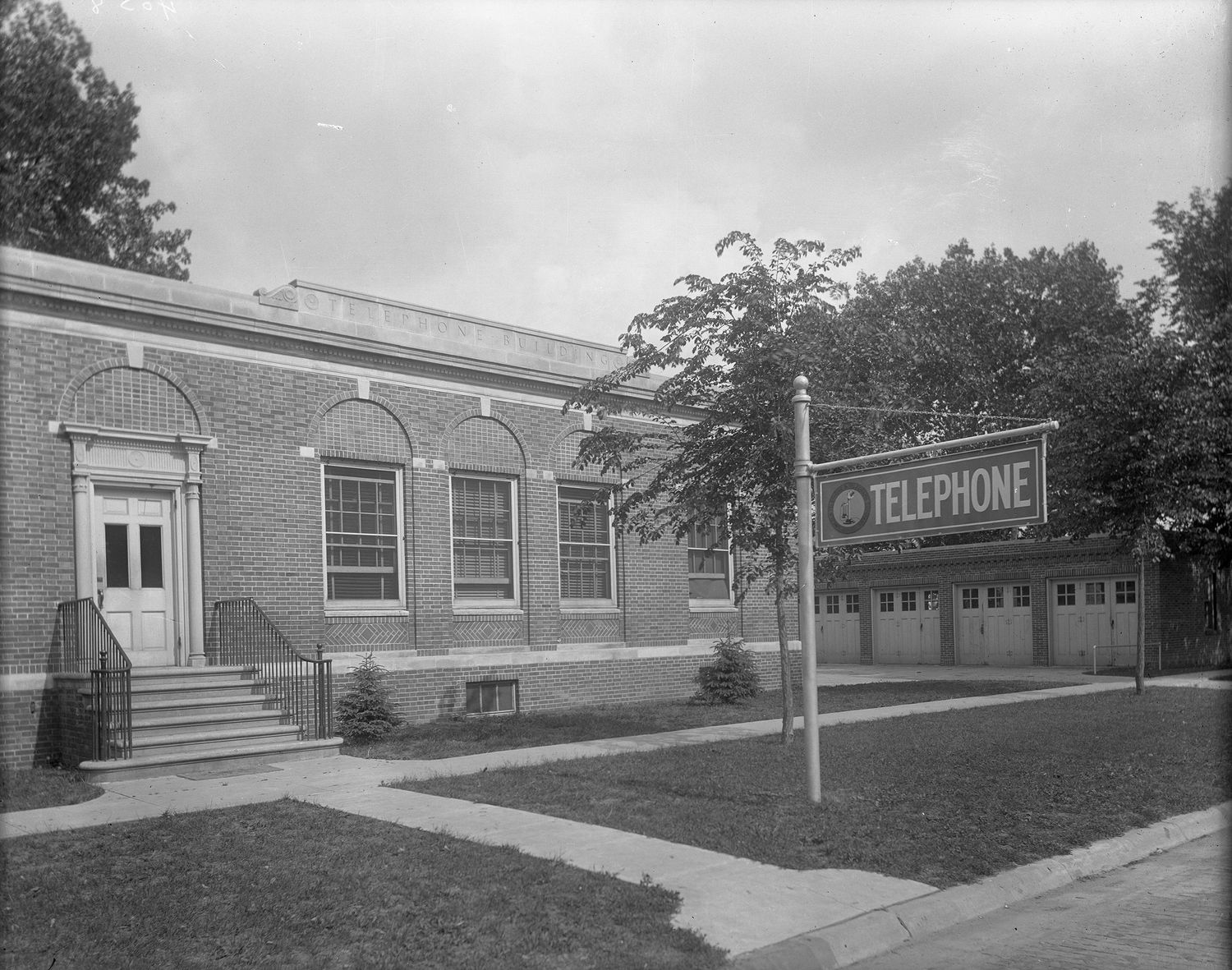 Black and white photograph of vintage telephone company building exterior.