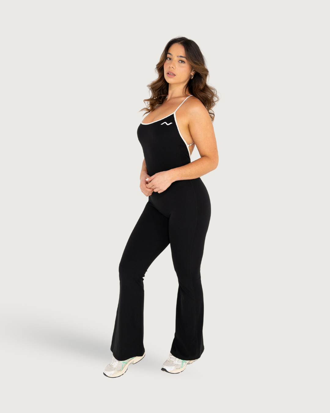 Model wearing a black athletic jumpsuit in different poses against a white background.