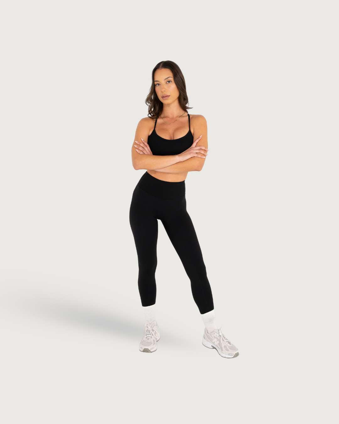 Athletic wear lifestyle shots showing black workout leggings and tank top ensemble.