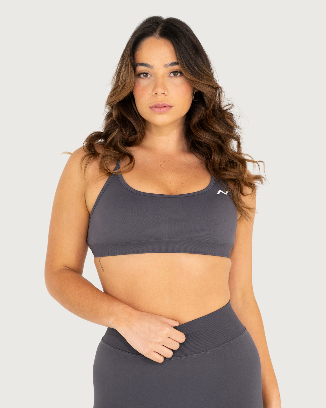Athletic model showcasing grey workout apparel in multiple poses against white backdrop.