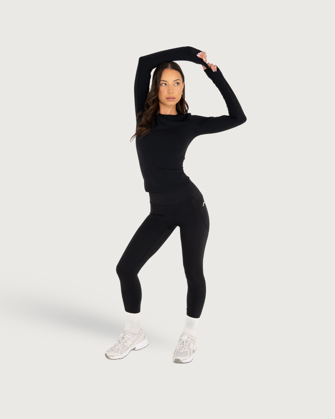 Athletic model demonstrating stretching poses in black workout attire against white background.