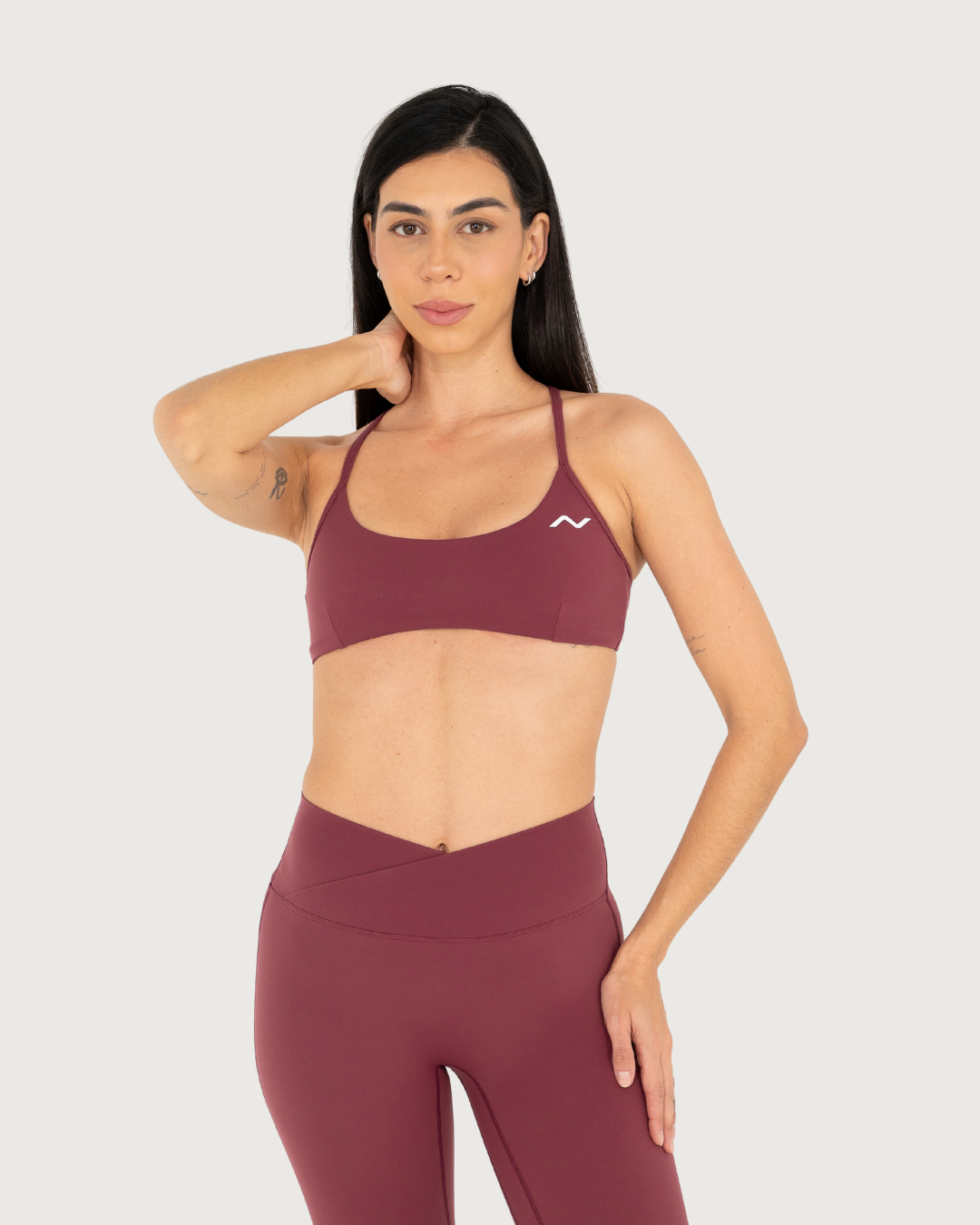 Athletic woman in burgundy workout set poses in multiple positions showing fitness apparel details.