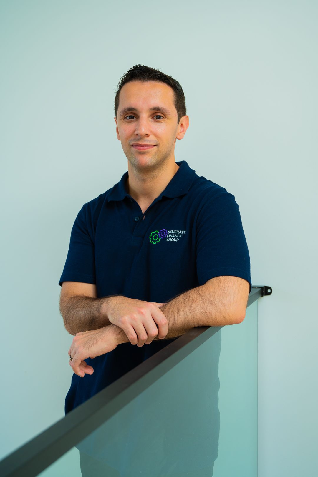 Company director in navy uniform poses against light blue wall.