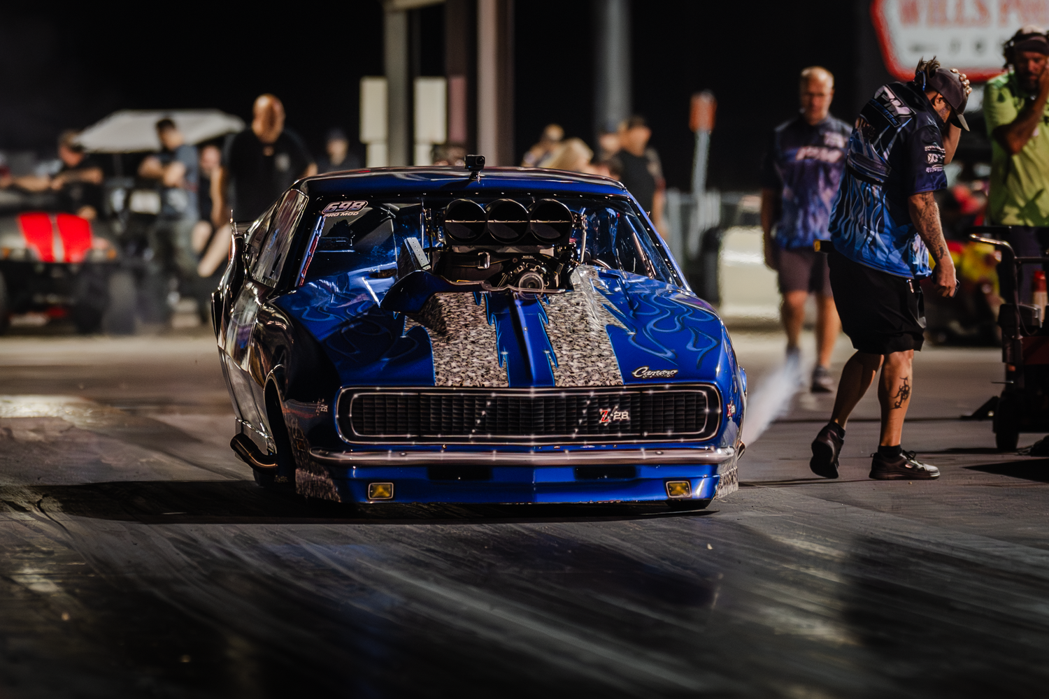Blue racing car photographed from multiple angles during a competitive motorsport event at an urban track.
