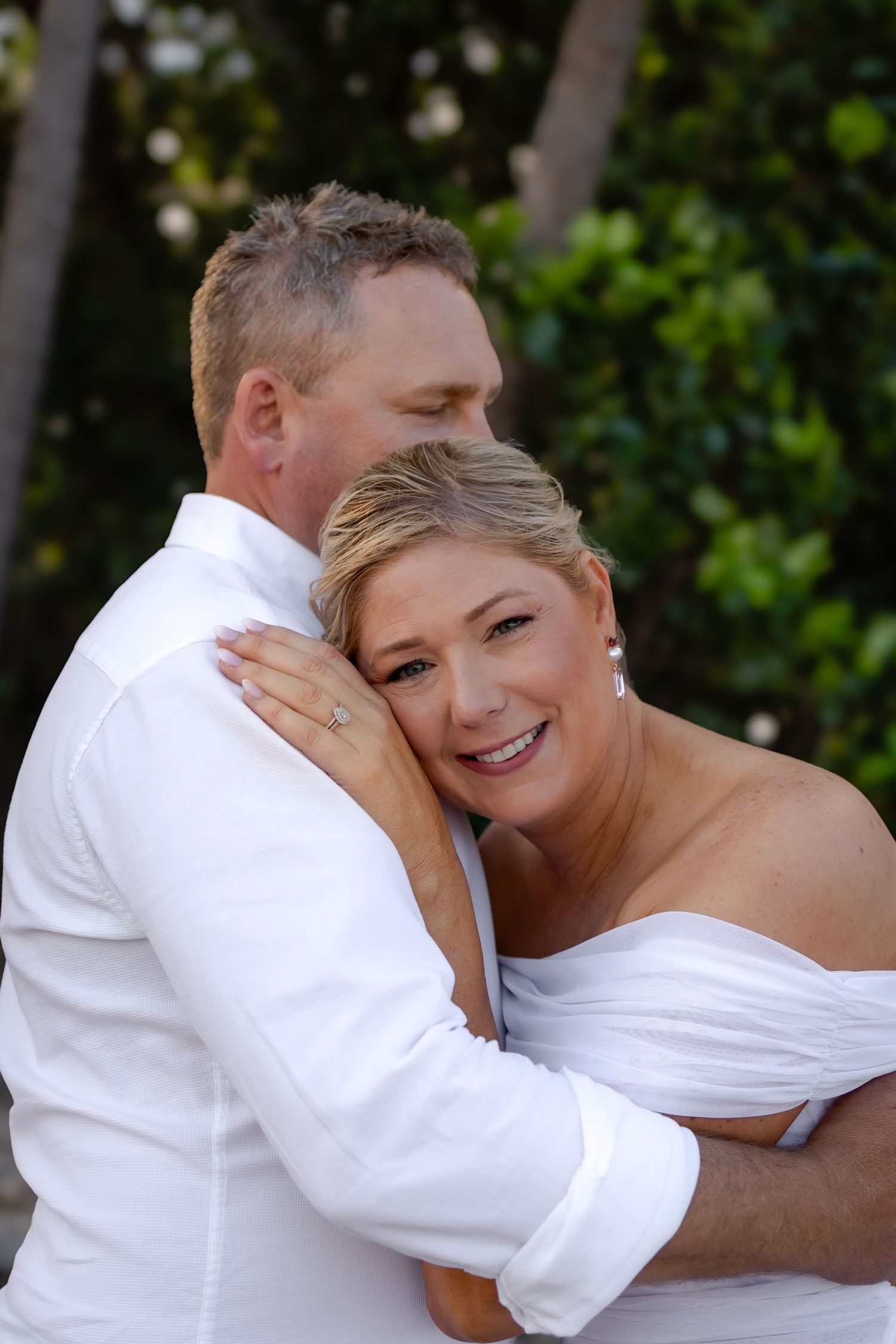 Intimate moments captured between couple in white attire.