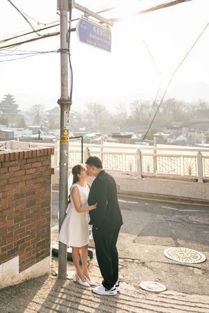 Couple sharing intimate moment on street during golden hour.