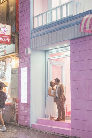 Purple building facade creates vibrant backdrop for romantic urban photography.