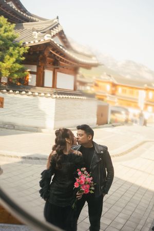 A couple shares romantic moments at a traditional Korean temple courtyard during golden hour.