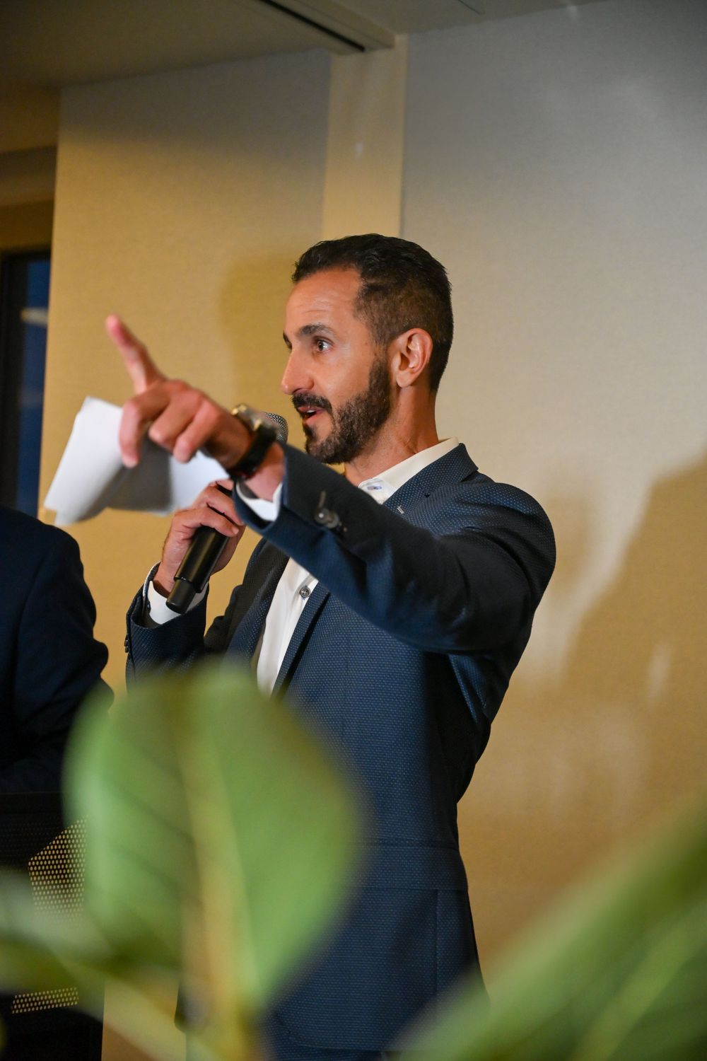 Man in a formal navy suit gestures animatedly in a sequence of dynamic party shots.