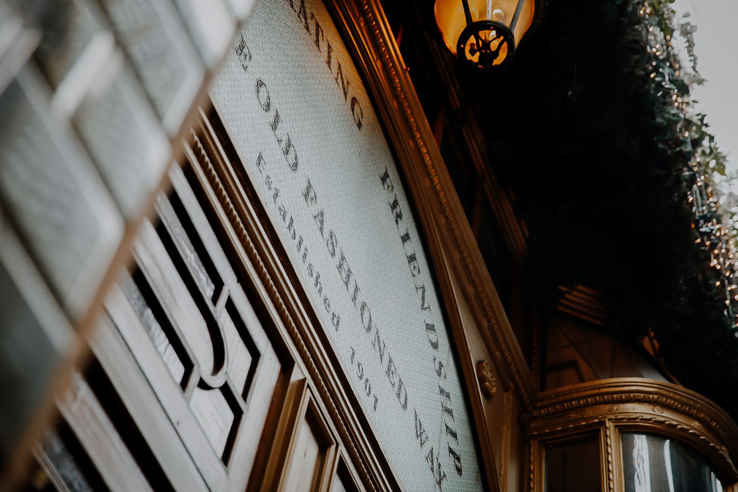 Architectural detail showing ornate wooden molding and white trim beneath a vintage pendant light fixture.