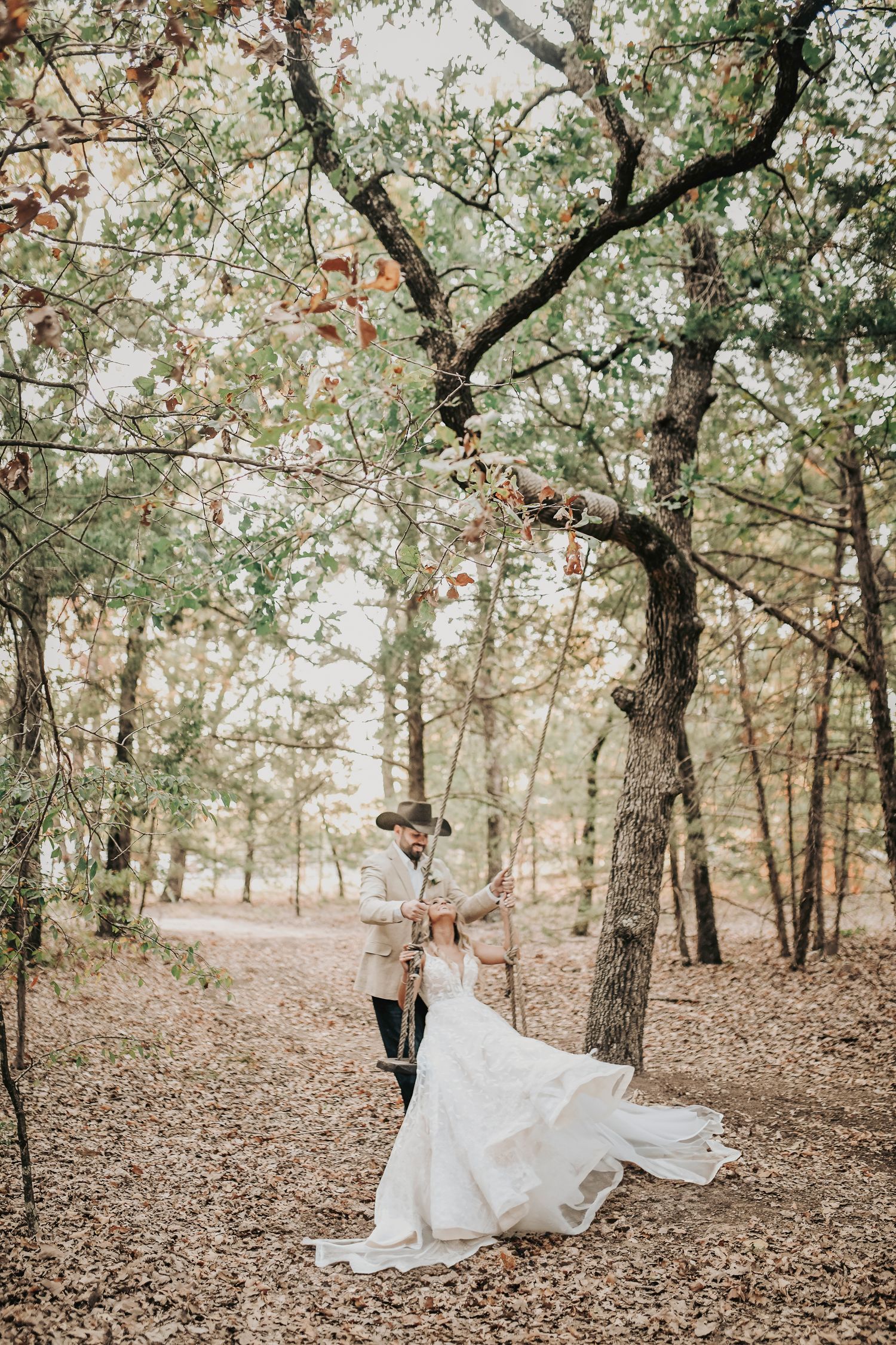 Bride and groom cuddled together on rustic swing at Whispering Oaks