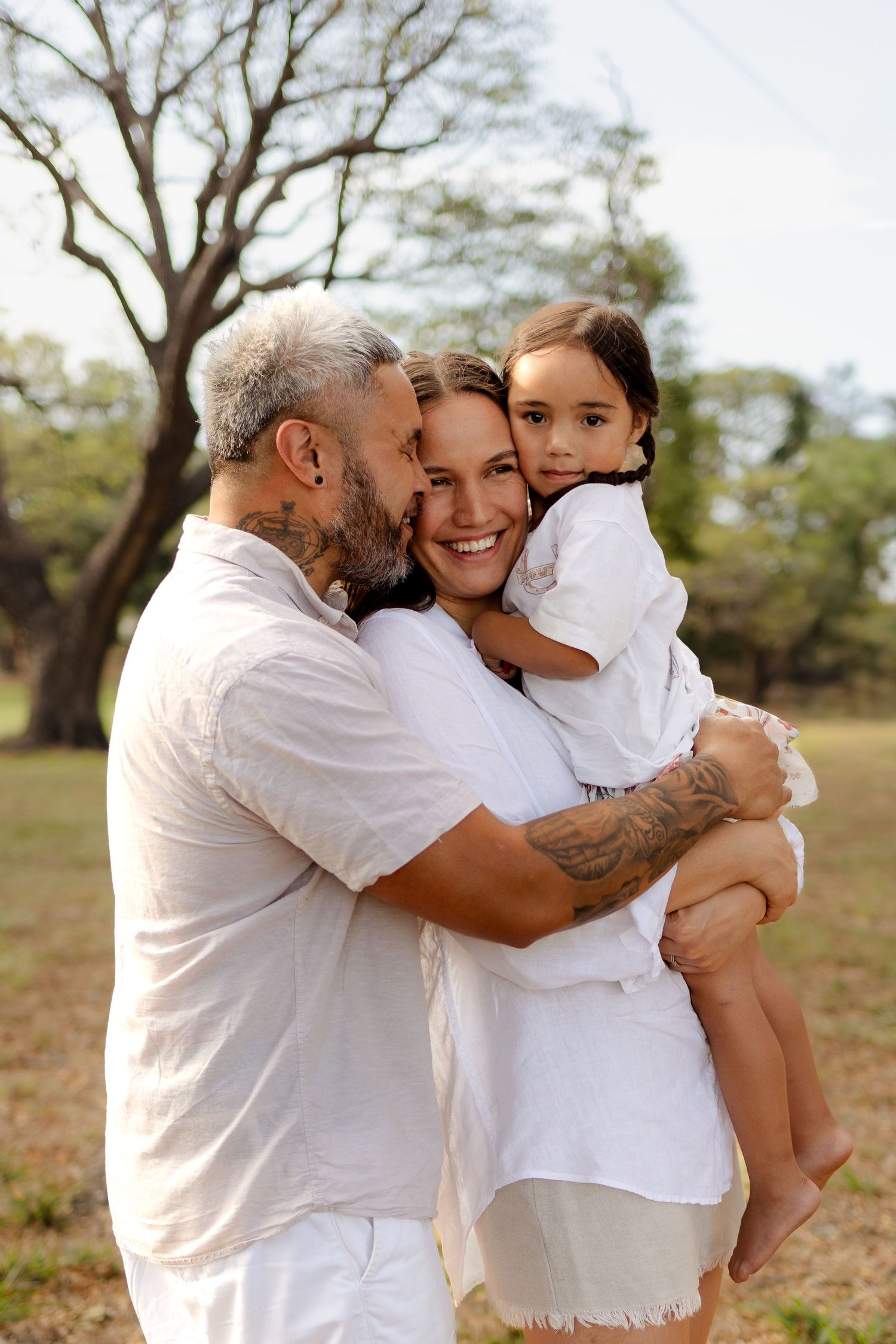 Heartwarming family embrace captured during golden hour in a park setting.