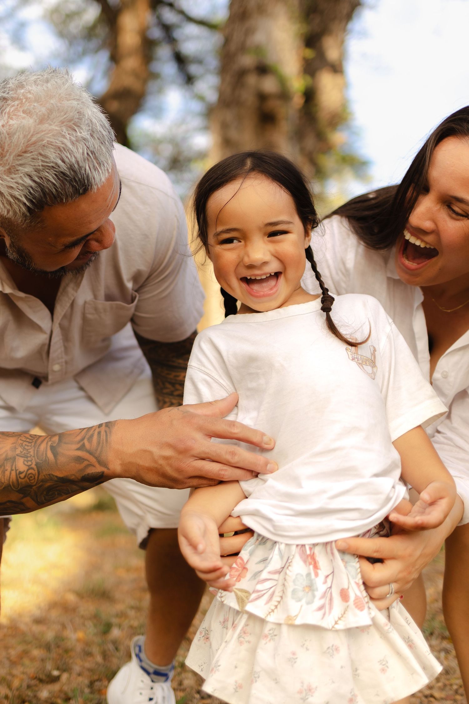Playful tickling moments captured during an outdoor family photoshoot.