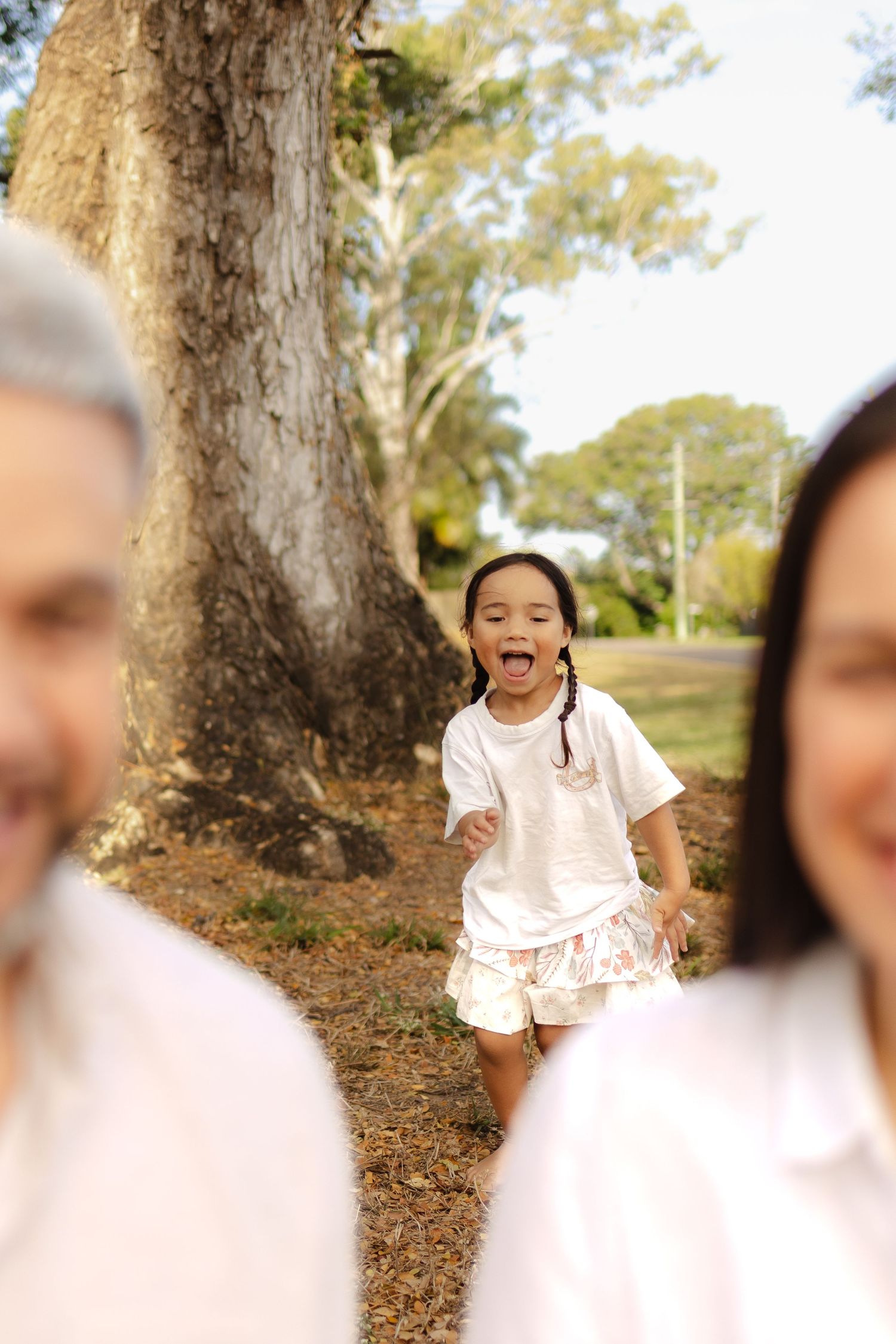 Natural family photography in a park setting with soft focus and genuine expressions.