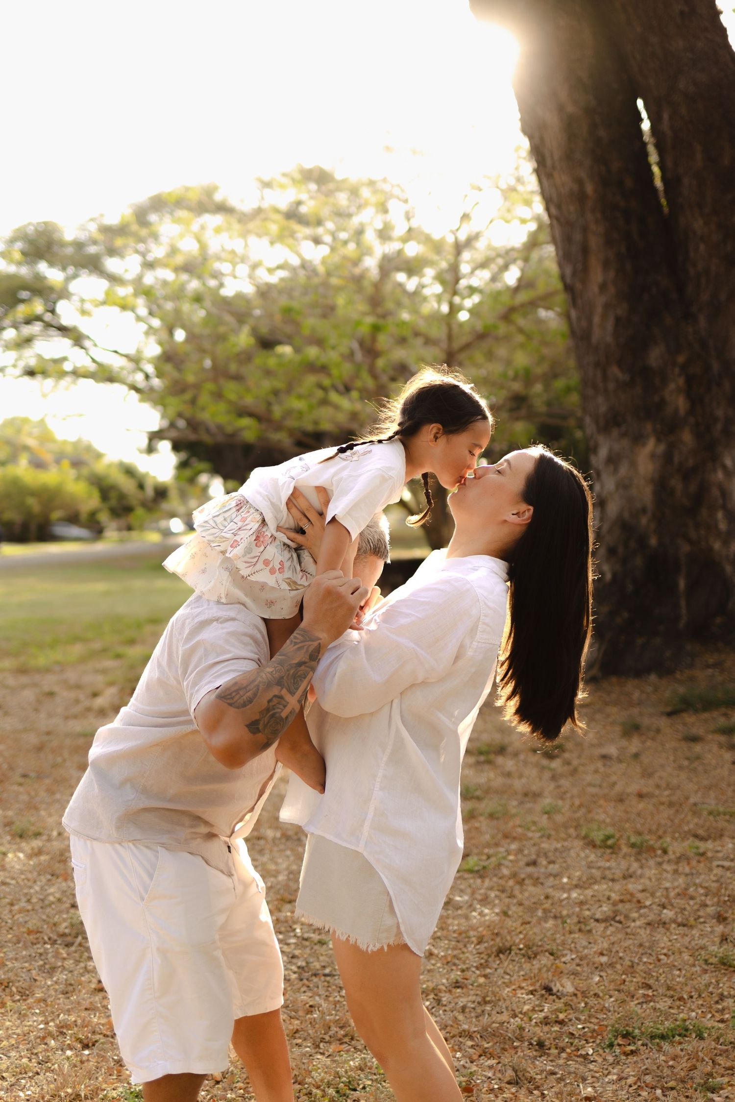 Family members playing and laughing together during a sunset photoshoot.