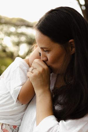 Intimate close-up shots of family affection during an outdoor portrait session.