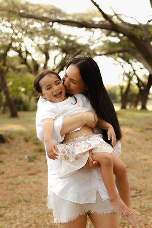 A joyful moment between parent and child playing outdoors in a park setting during golden hour.