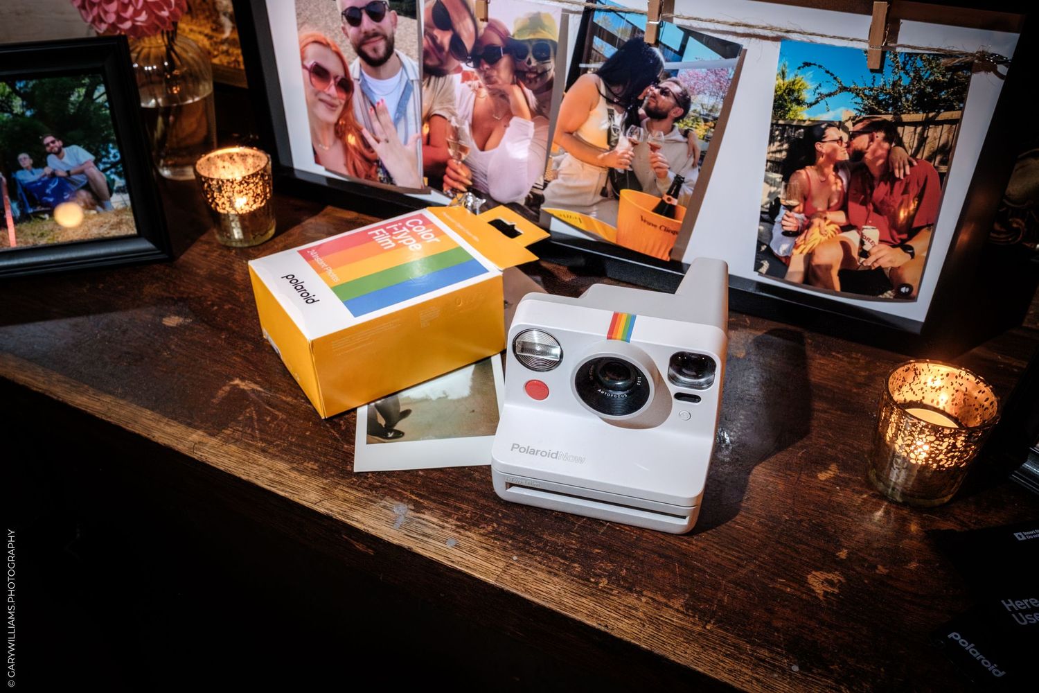 Wedding memories displayed on wooden surface with photo albums, candles, and decorative elements in warm light.