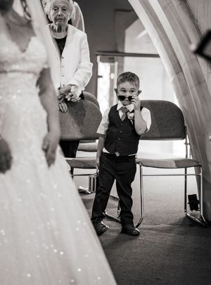A sequence of black and white images showing a young boy in formal attire walking and playing during a wedding reception.