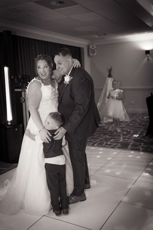 A series of black and white photos capture tender moments between a couple and child during a wedding reception dance.