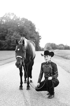 Black and white photo series showing a small child kneeling with a black pony on a road.