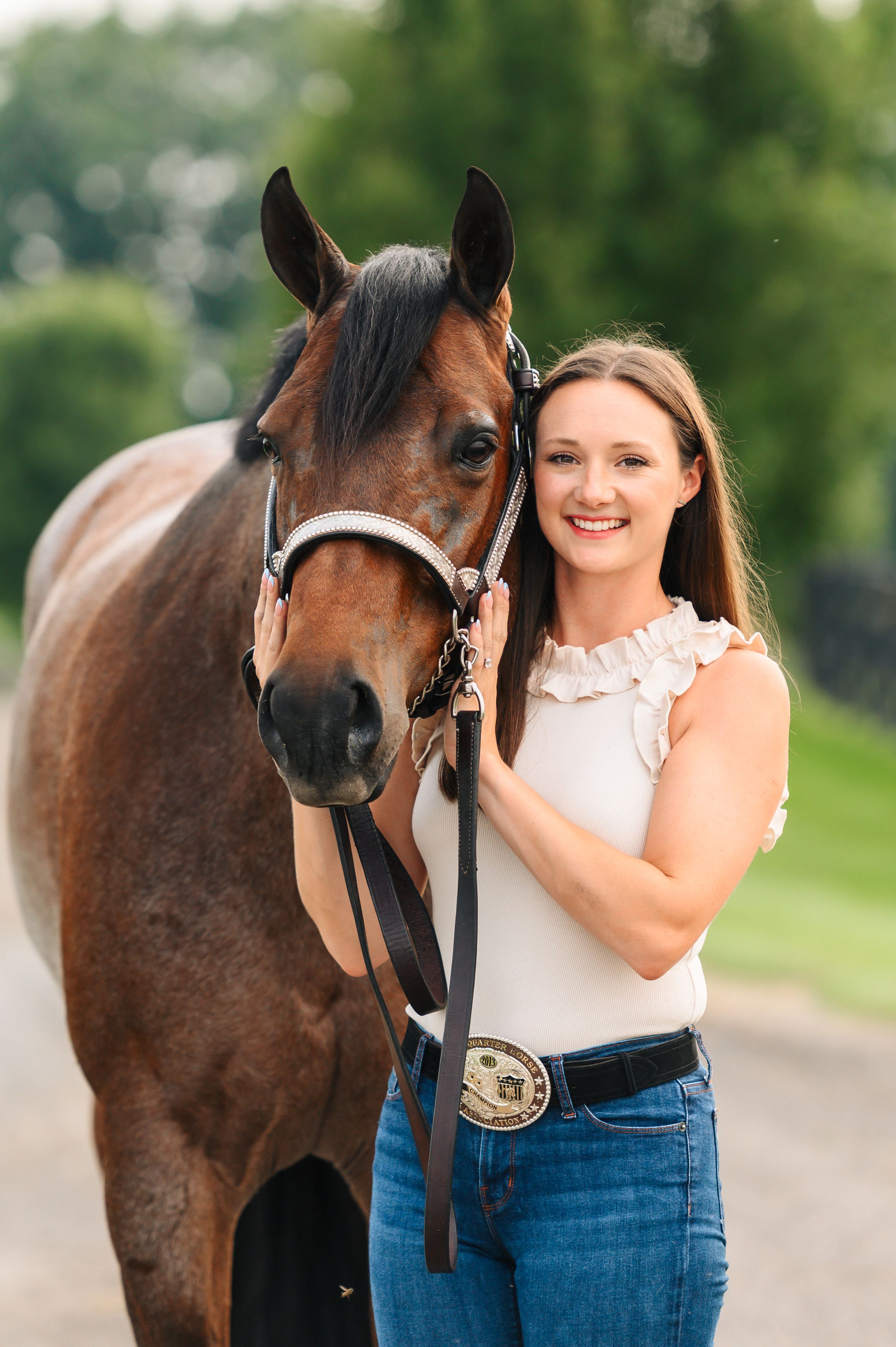 Beautiful brown horse and person standing together outdoors in casual summer photography session.