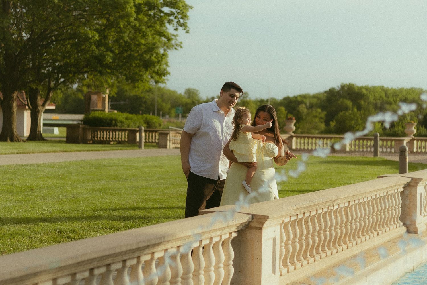 Couple sitting by a reflective pool at sunset creating romantic silhouettes against classical architecture.
