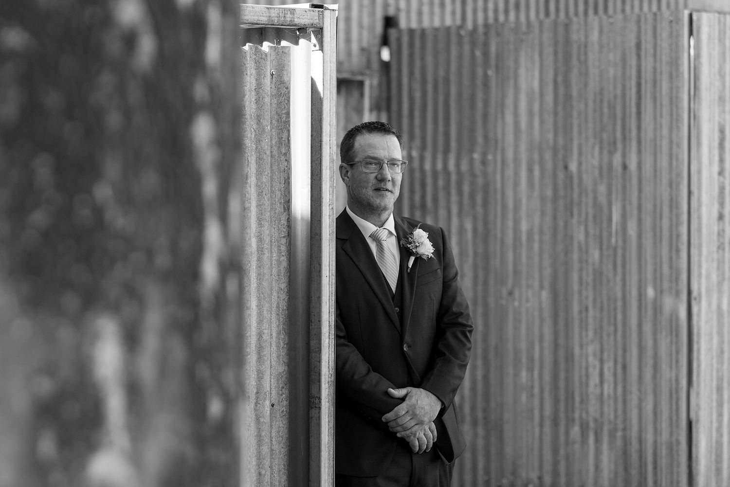 A black and white portrait of a Groom in his suit with a white button hole flower on his jacket at Buller Wines in Rutherglen.