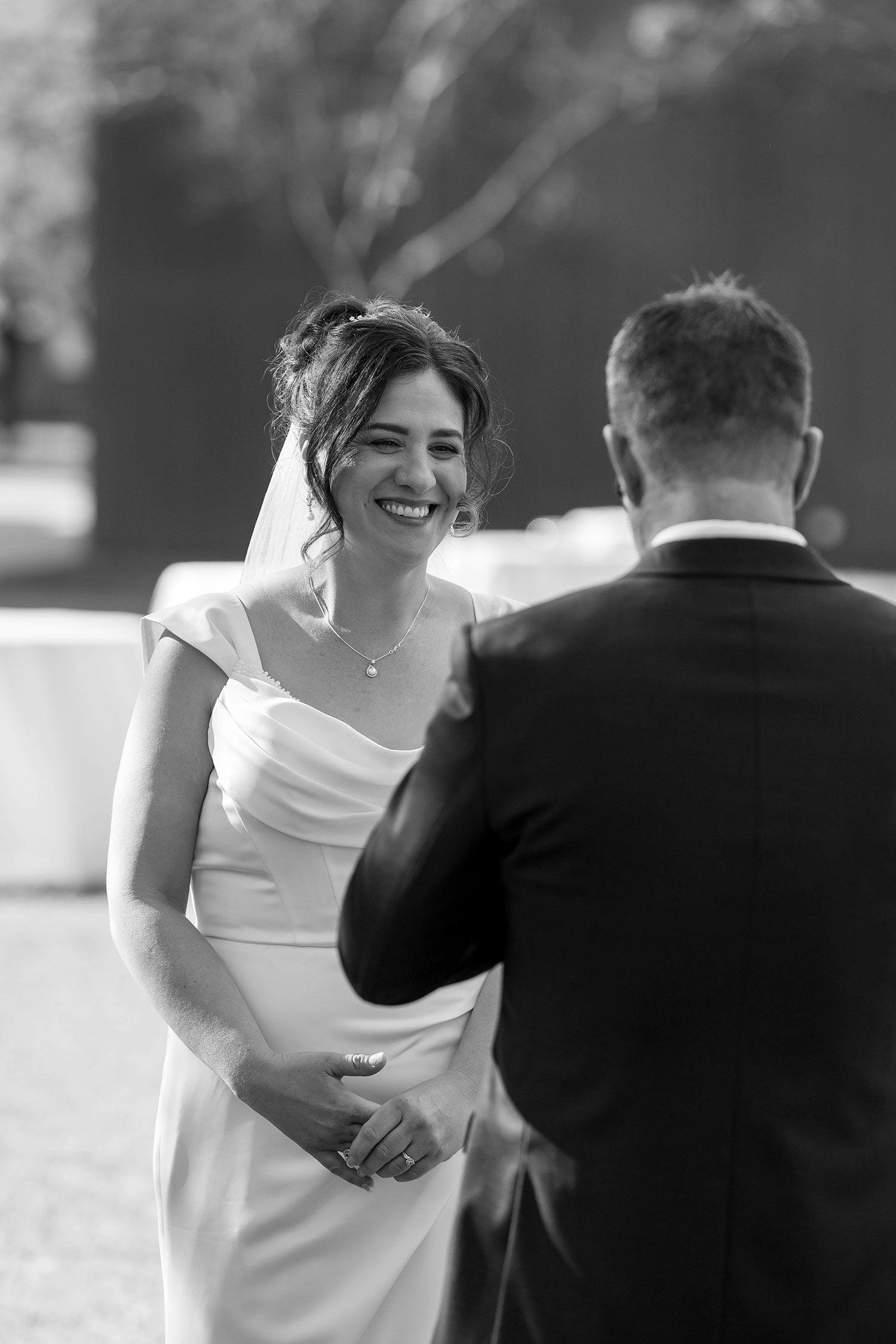 A black and white image of a special moment between a bride in a white dress and groom at an outdoor wedding celebration at Buller Wines.