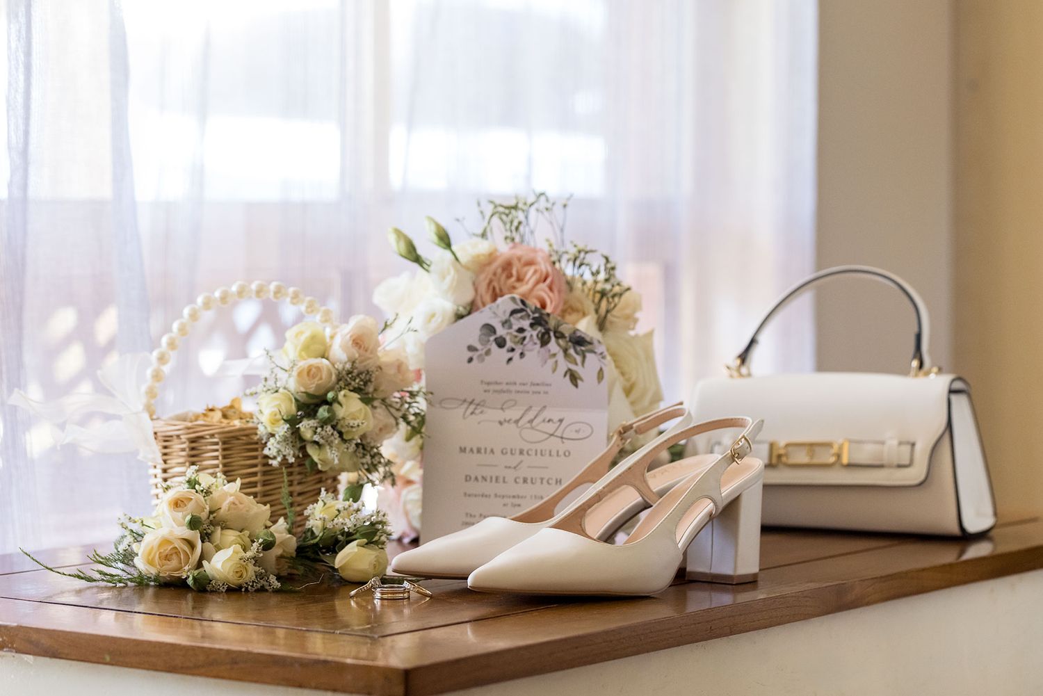 An elegant wedding setup with white floral centre pieces and crystal glasses on a wooden table.