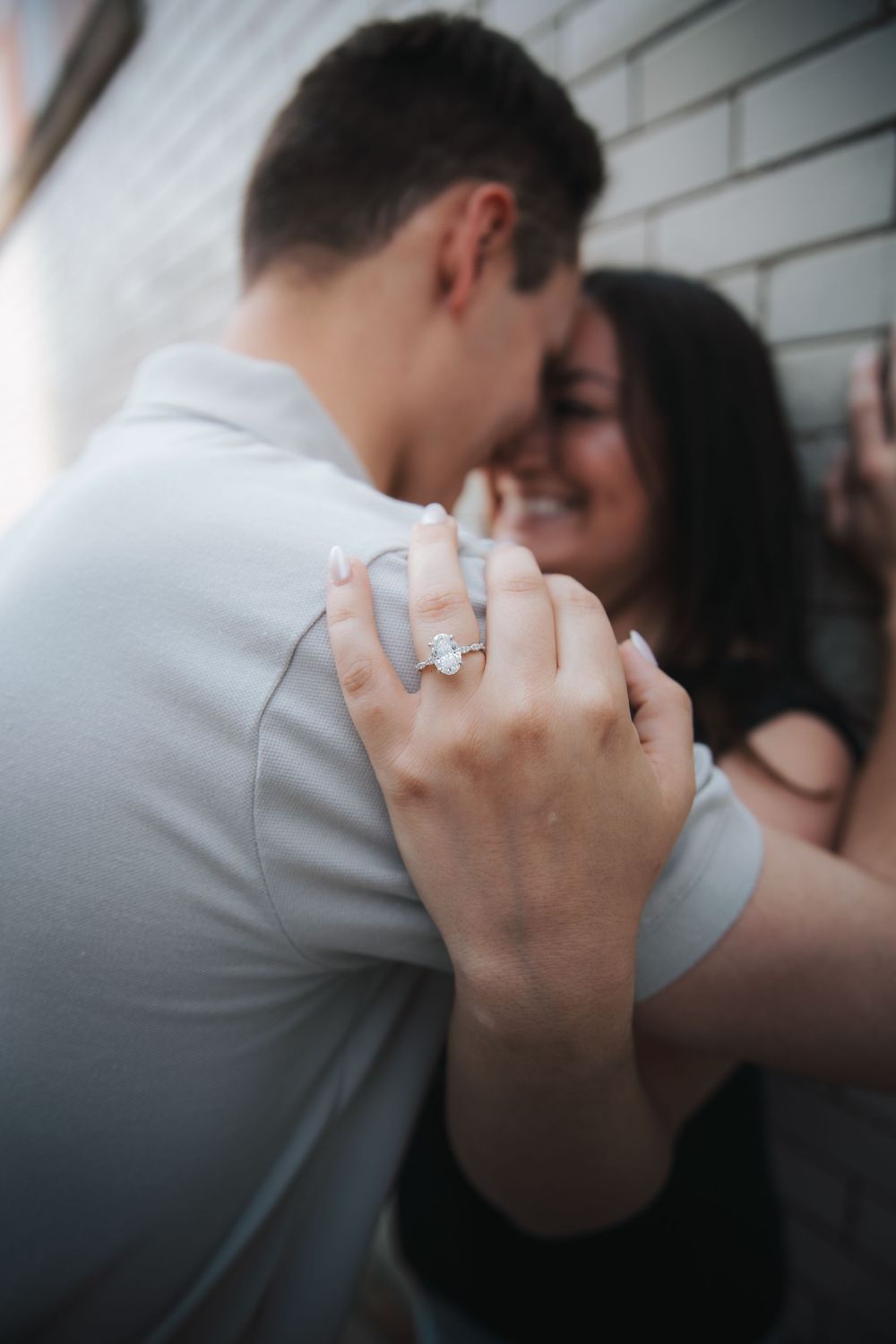 An intimate moment showing clasped hands with an engagement ring prominently displayed.